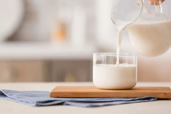 Menuangkan susu dalam gelas